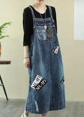 Vestido túnica con letras en azul vaquero intenso y escote oblicuo. Vestido largo con agujeros.